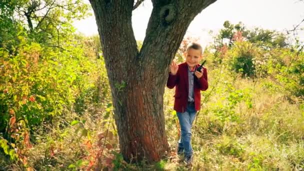 Αγόρι με ένα γουόκι-talk στη φύση — Αρχείο Βίντεο