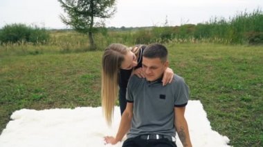 Çimenlikte oturan genç bir çift