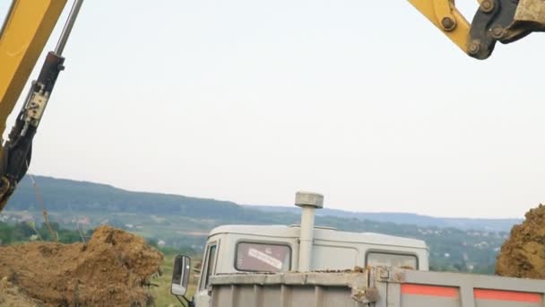Grävmaskin laddar en lastbil — Stockvideo