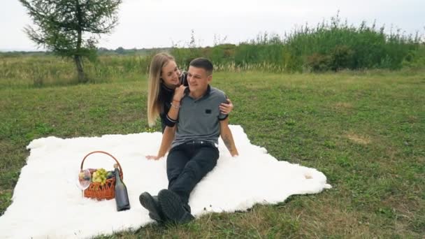 Młoda para siedzi na trawnik — Wideo stockowe