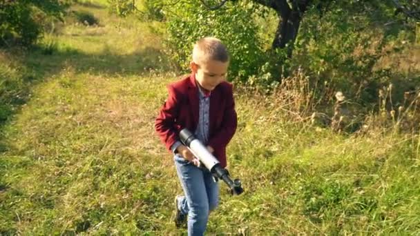 Αγόρι με ένα τηλεσκόπιο στη φύση — Αρχείο Βίντεο