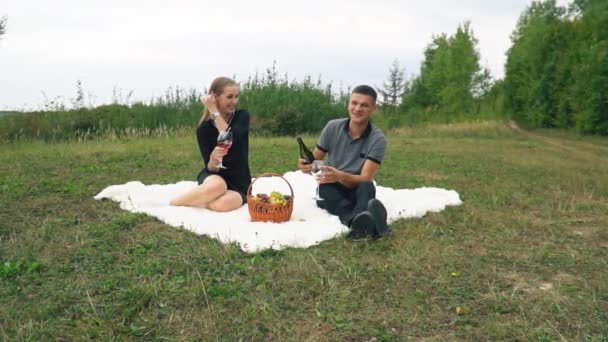 Ungt par sitter på gräsmattan — Stockvideo