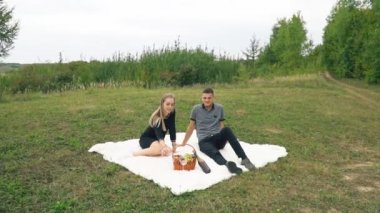 Çimenlikte oturan genç bir çift