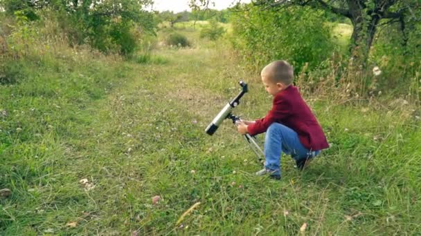 Pojke med ett teleskop i naturen — Stockvideo