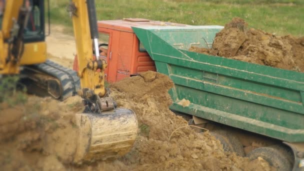 Graafmachine Laadt Vrachtwagen Met Aarde — Stockvideo