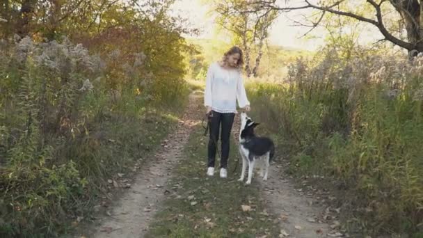 自然の中にハスキー犬の品種を持つ少女 — ストック動画