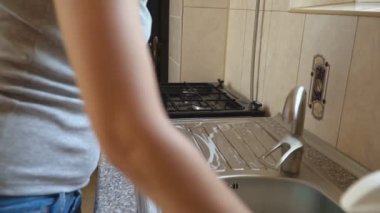 kadının bulaşıkları yıkar