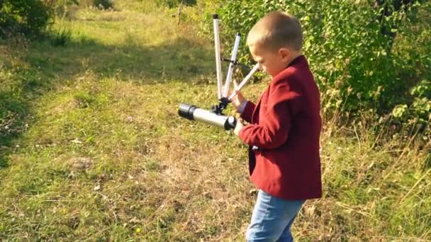 Junge mit Teleskop in der Natur — Stockvideo