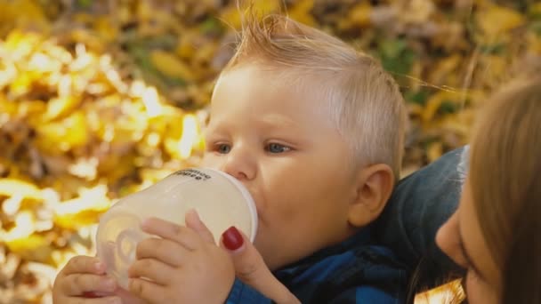 Мать кормит своего ребенка из бутылки — стоковое видео