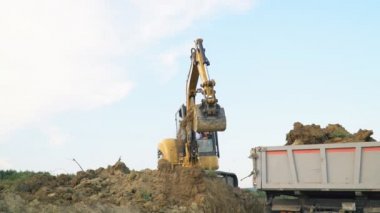 Ekskavatör earth ile kamyon yükler