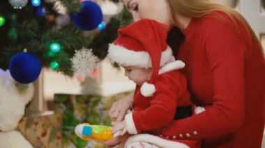 Anne ile bebek Noel ağacı yakınındaki