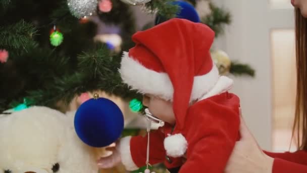 Madre con el bebé cerca del árbol de Navidad — Vídeos de Stock