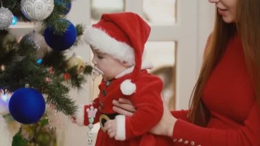 Anne ile bebek Noel ağacı yakınındaki