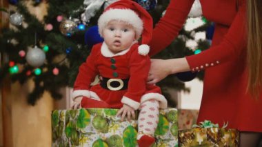 Anne ile bebek Noel Baba kostüm bakarak sunar