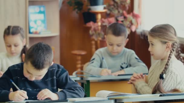 Kinderen schrijven vergadering op een bureau — Stockvideo