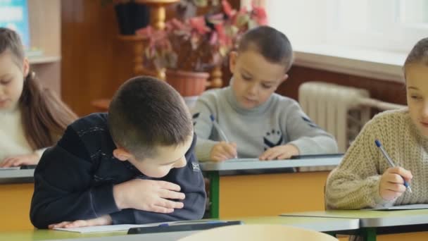 Kinderen schrijven vergadering op een bureau — Stockvideo