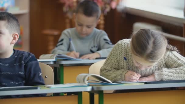 Děti psát sedící u stolu — Stock video