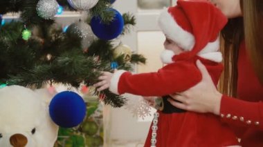 Anne ile bebek Noel ağacı yakınındaki