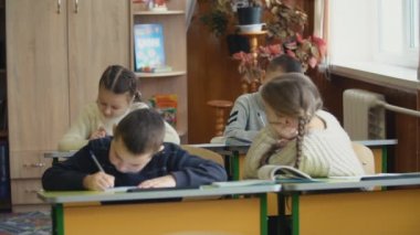 Bir masada oturan çocuk yazmak