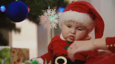 küçük kız Noel Baba olarak anne ile giyinmiş.