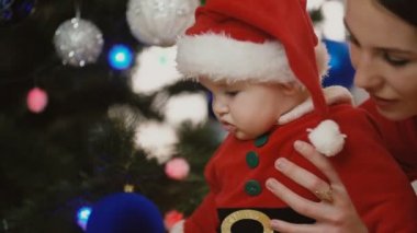 küçük kız Noel Baba olarak anne ile giyinmiş.
