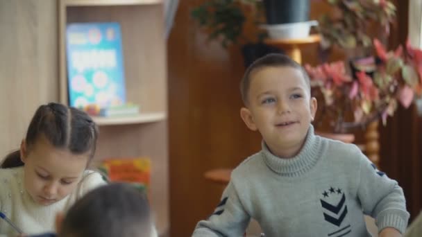 Kinderen schrijven vergadering op een bureau — Stockvideo