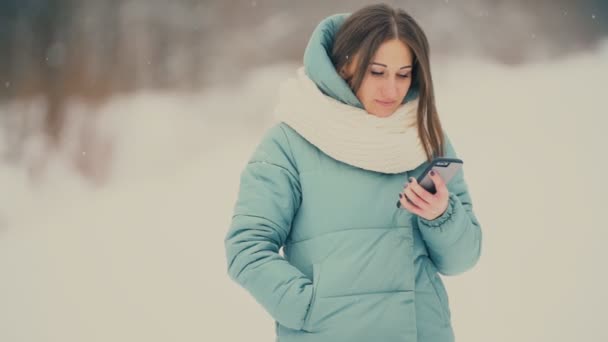 Menina olha para o telefone — Vídeo de Stock