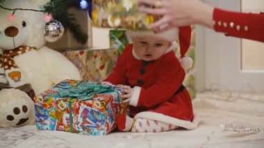 Anne ile bebek Noel Baba kostüm bakarak sunar