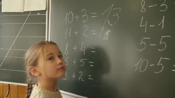 Klein meisje in de buurt van de Raad van bestuur beslist de berekeningen — Stockvideo