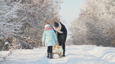 Anne kızı bir kızak üzerinde rulo.