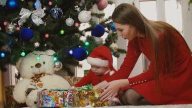 Anne ile bebek Noel Baba kostüm bakarak sunar