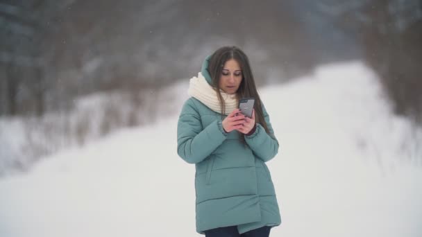 Chica mira en el teléfono — Vídeos de Stock