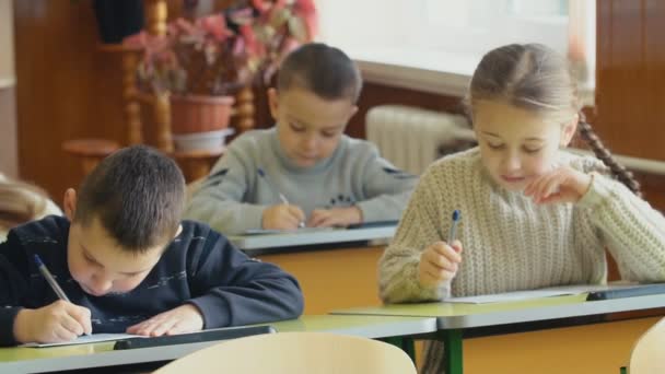 Kinderen schrijven vergadering op een bureau — Stockvideo