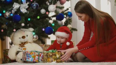 Anne ile bebek Noel Baba kostüm bakarak sunar