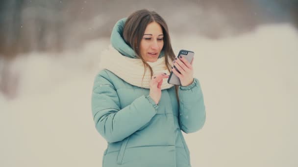 Flickan ser i telefonen — Stockvideo