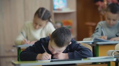 Bir masada oturan çocuk yazmak