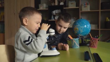 Çocuklar mikroskop bir şey bakıyor