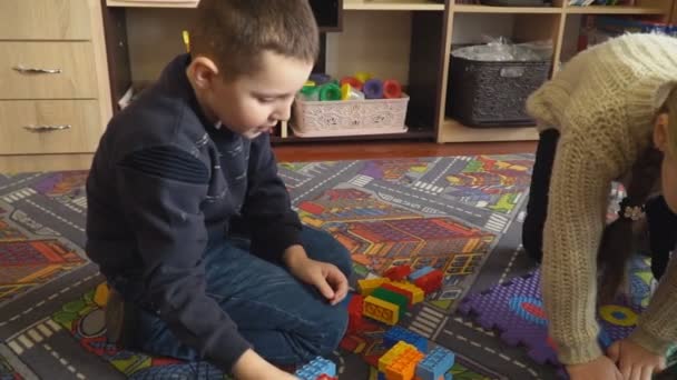 Niños juegan con el diseñador de los cubos — Vídeo de stock