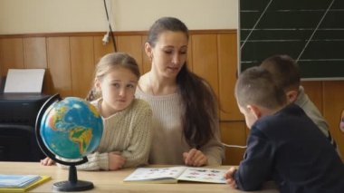 çocuklar ile öğretmen bir kitap görüntülemek
