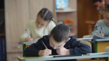 Bir masada oturan çocuk yazmak
