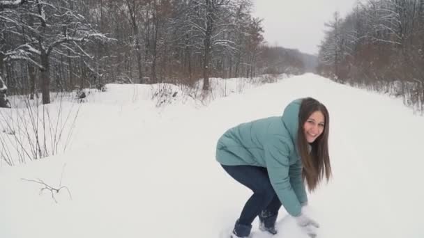 Flickan rinner genom den snöiga parken — Stockvideo