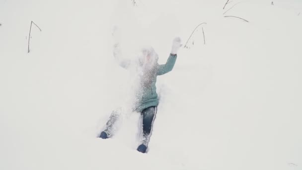 Дівчина робить ангела в снігу — стокове відео
