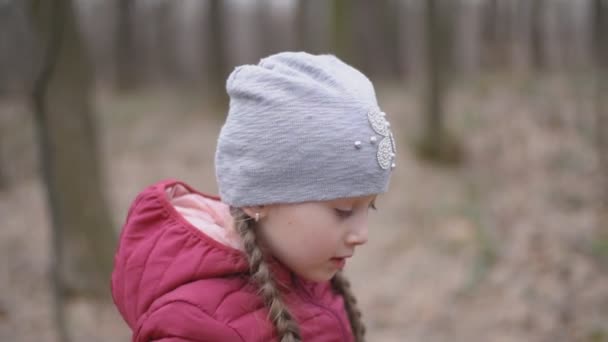 Meisje verzamelt sneeuwklokjes — Stockvideo