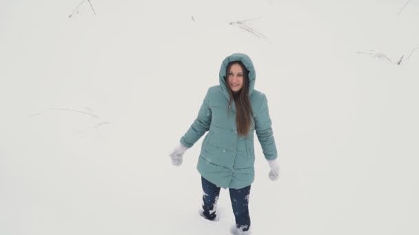 Девушка делает ангела в снегу — стоковое видео