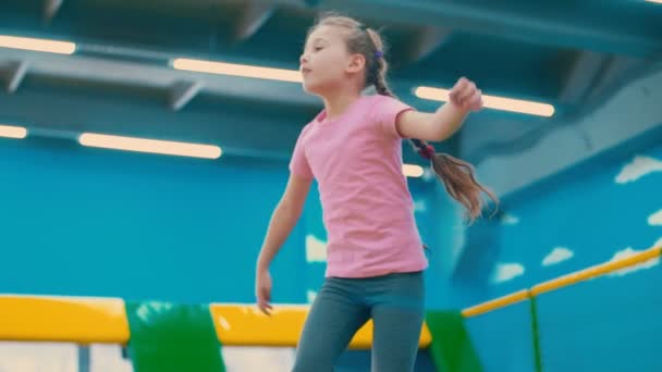 Маленькая девочка прыгает на батуте — стоковое видео