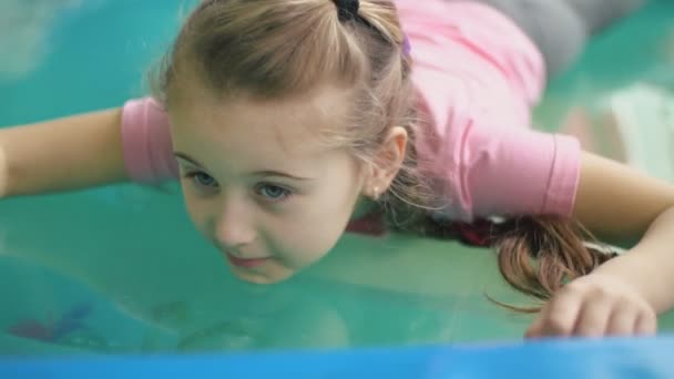Девушка, сидящая в бассейне — стоковое видео