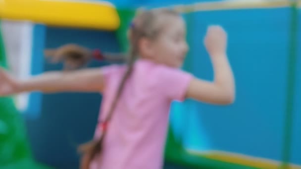 Маленька дівчинка стрибає на батуті — стокове відео