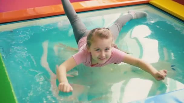 Menina sentada na piscina — Vídeo de Stock