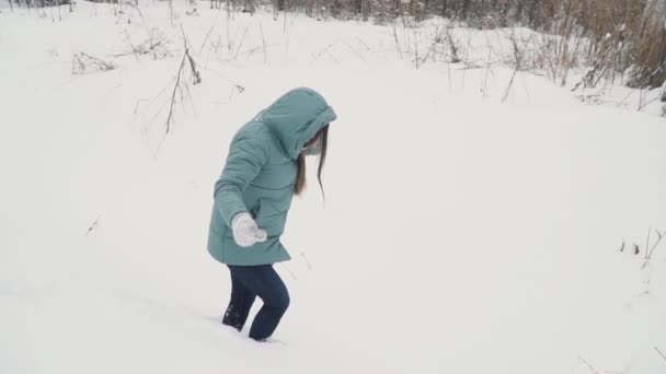 Frau geht im Schnee spazieren — Stockvideo