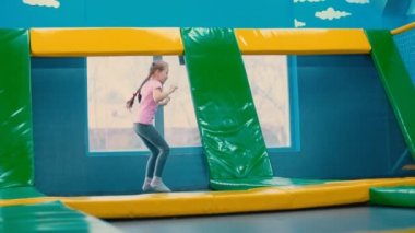 Trambolinde zıplayan küçük kız